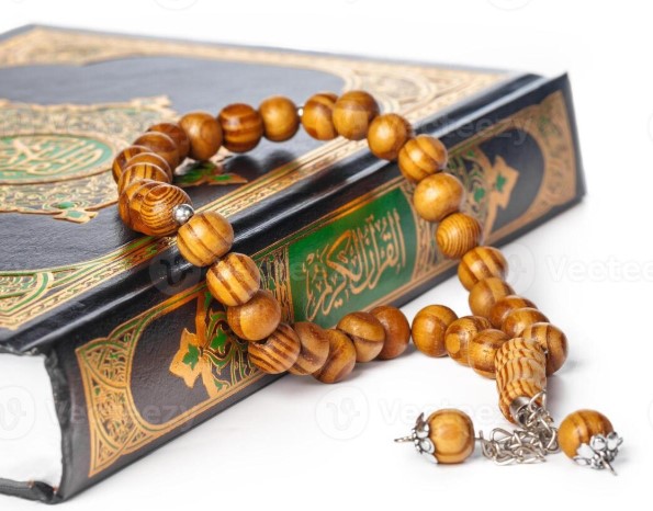 Tasbih Islamic prayer beads made of wood resting on a Quran