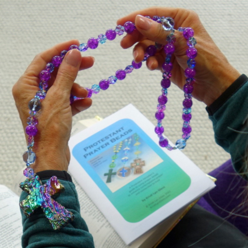 Woman's hands holding Protestant prayer beads above how-to-pray booklet