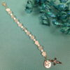 White Protestant chaplet bracelet with white shell flower beads, crackle glass, rhinestone cross, and loved heart pendant