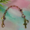 Pink Roses Protestant chaplet bracelet with rose ceramic beads, pink cat’s-eye glass, goldtone metal cross, and BE STILL AND KNOW pendant