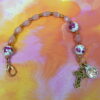 Pink Roses Protestant chaplet bracelet with rose ceramic beads, pink cat’s-eye glass, goldtone metal cross, and BE STILL AND KNOW pendant