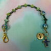 Rainbow Crosses Protestant chaplet bracelet with iridescent glass beads, silver-plated cross beads, and Believe pendant